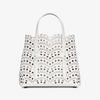 White handbag with black polka dot pattern on a white background