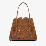 Brown perforated handbag on a white background