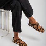 Person wearing leopard print flats and black jeans on a white background