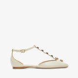 White flat shoe with decorative straps on a white background