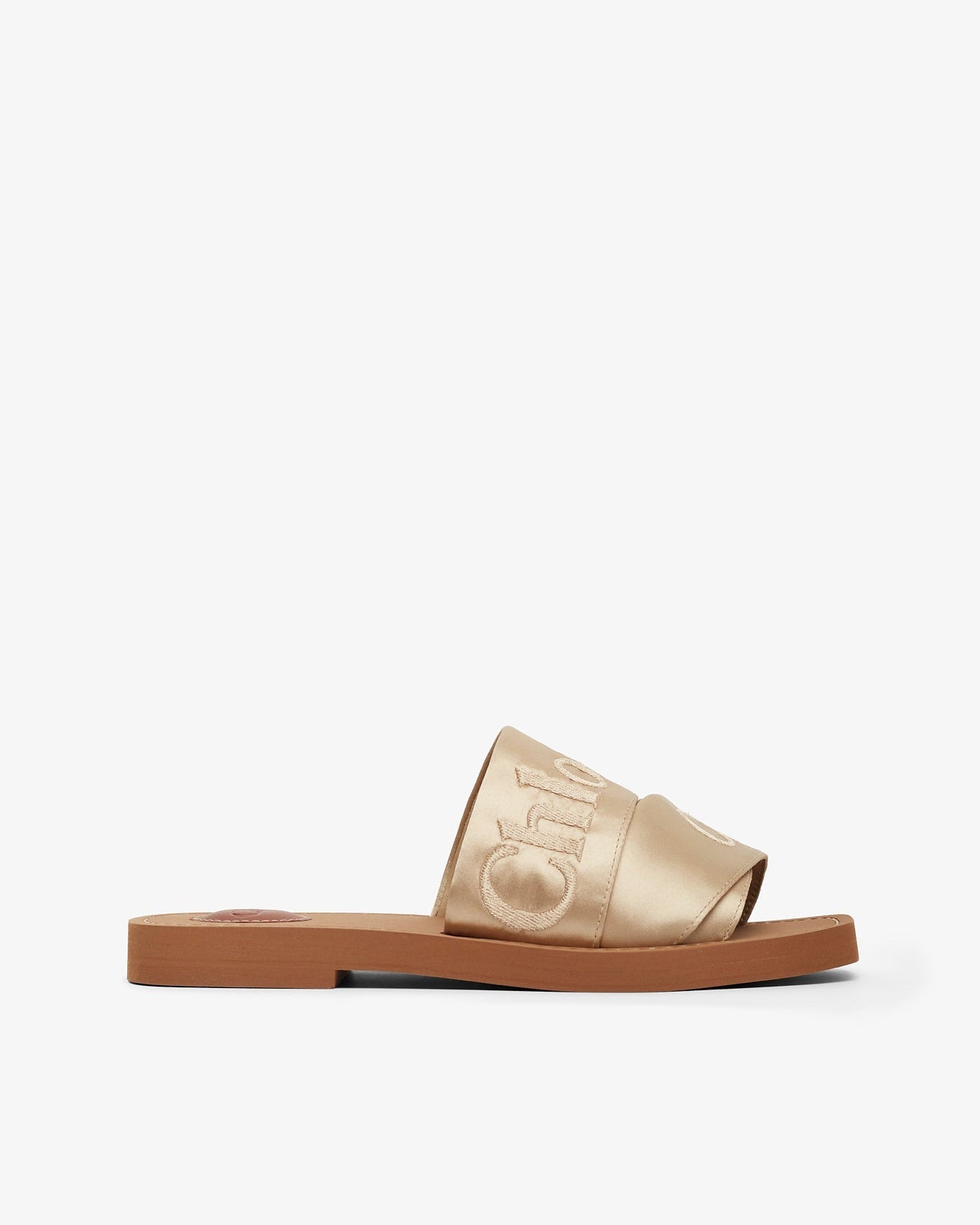 Gold slide sandal with brand logo on a white background