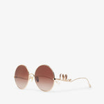 Round sunglasses with gold frame and brown gradient lenses on a white background