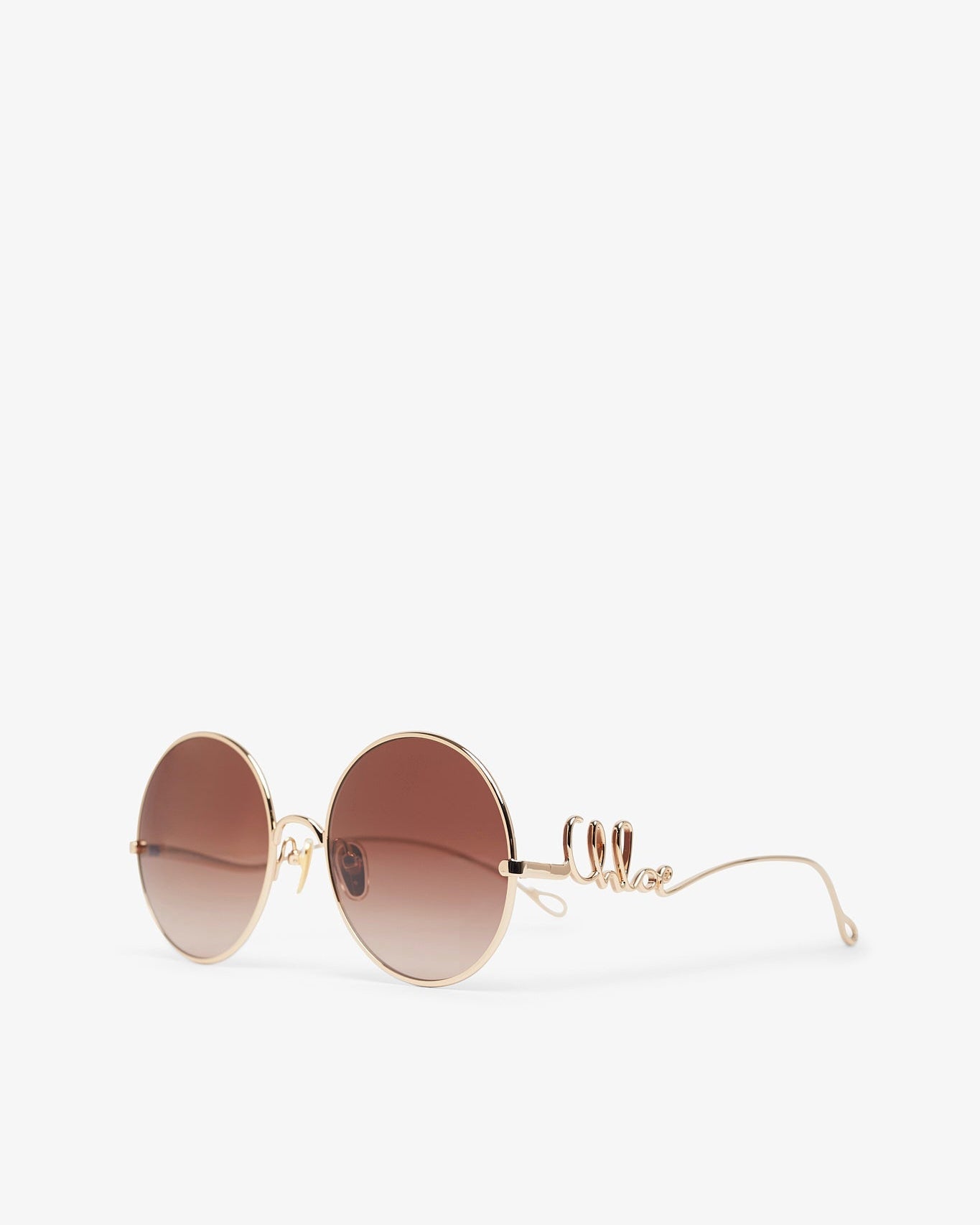 Round sunglasses with gold frame and brown gradient lenses on a white background