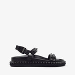 Black sandal with studded details on a white background