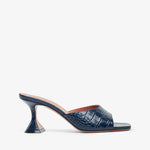 Navy blue high-heeled shoe with a subtle pattern on a white background