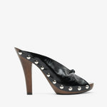Black high-heeled shoe with studded details on a white background