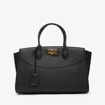 Black handbag with gold accents on a white background